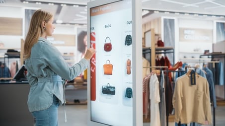 Female Customer Using Floor-Standing LCD Touch Display while Shopping in Clothing Store